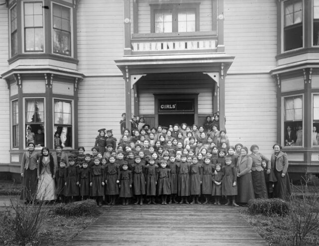 A class of girls pose for a picture outside a girl's boarding school.