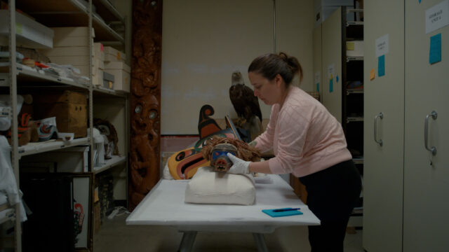 U’mista Cultural Centre’s Executive Director Juanita Johnston (Weḵa'yi / Haida) with regalia from the Potlatch Collection.