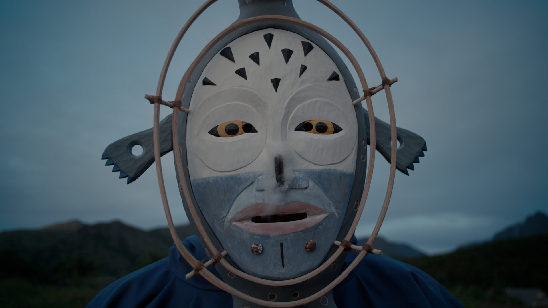 Ossie Kairaiuak (Yup’ik) of the musical group Pamyua dances a mask carved by Yup’ik artist Drew Michael.